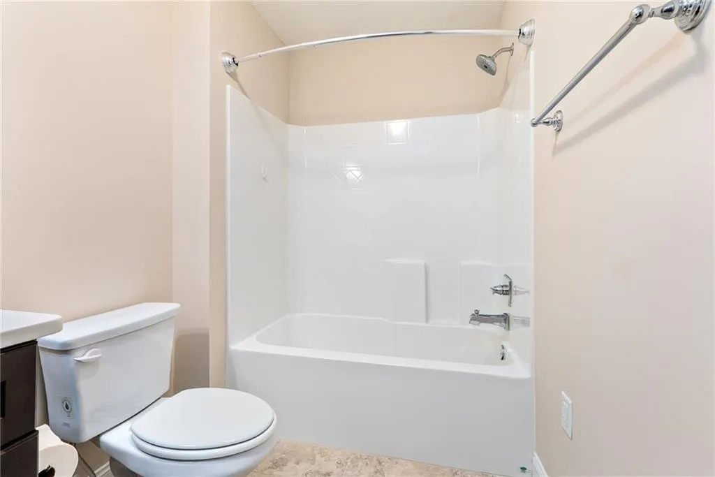 A pristine bath and shower combo offers clean lines and comfortable functionality.