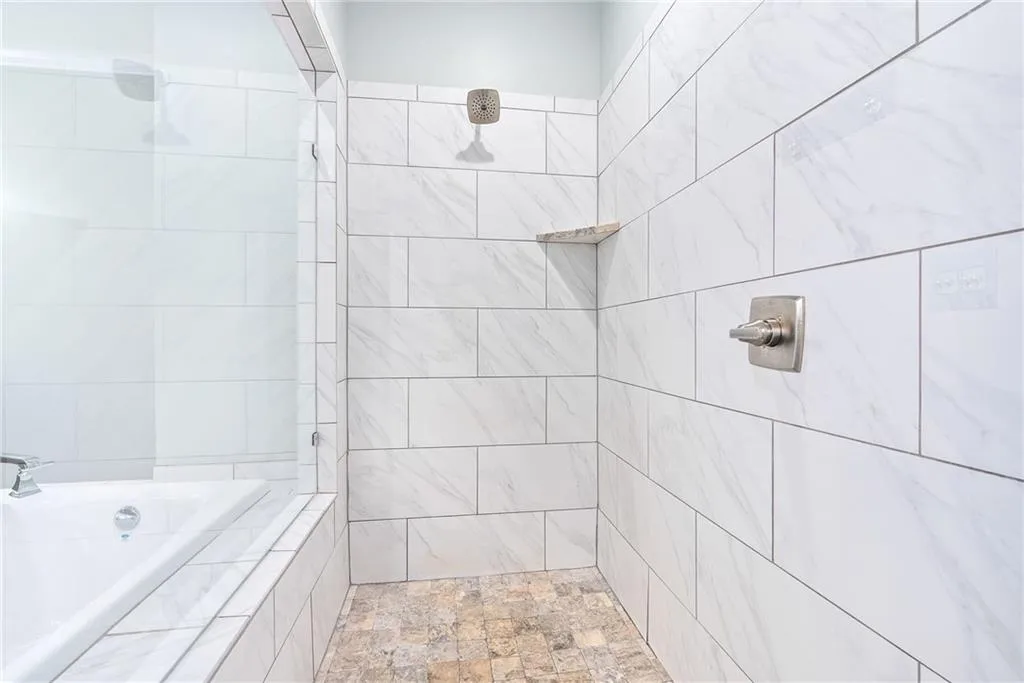 Indulge in a rejuvenating shower experience within this beautifully tiled, modern bathroom.
