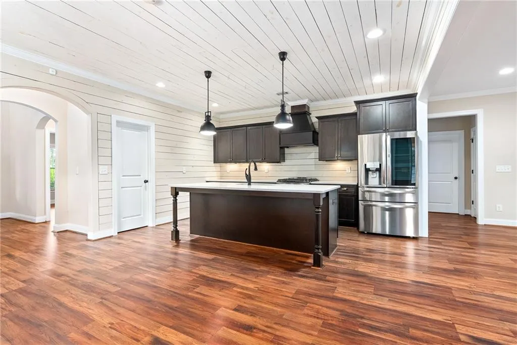An inviting open-concept kitchen features a spacious island and modern stainless steel appliances.