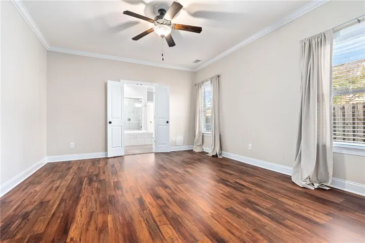 Hardwood floors and a ceiling fan create a comfortable ambiance in this restful retreat.