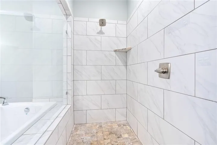 Indulge in a rejuvenating shower experience within this beautifully tiled, modern bathroom.