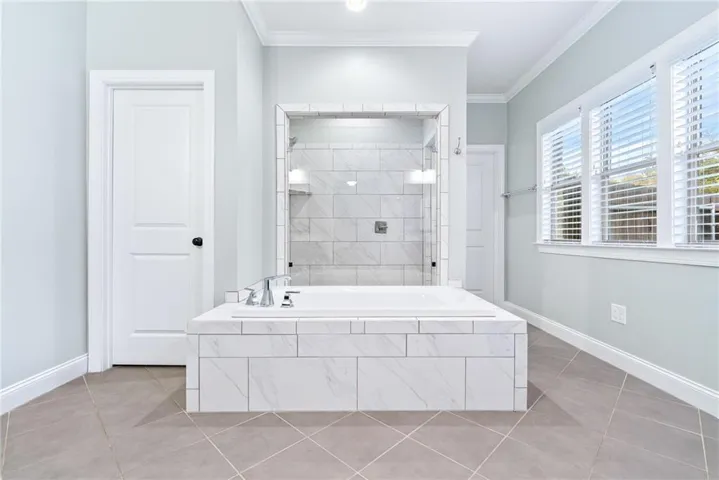 Luxurious bathroom with a spacious soaking tub and an elegant tiled shower.