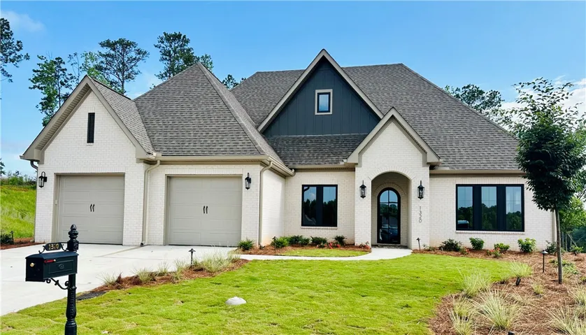 A newly constructed residence showcasing classic brick construction and a manicured front lawn.