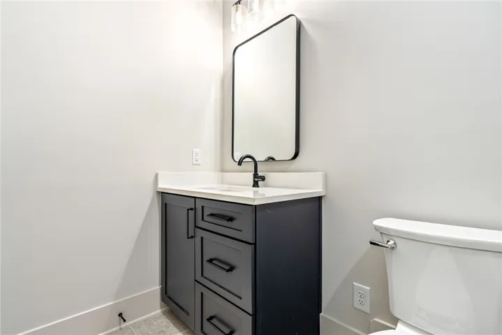 This clean and bright bathroom features a modern vanity and a sleek mirror.
