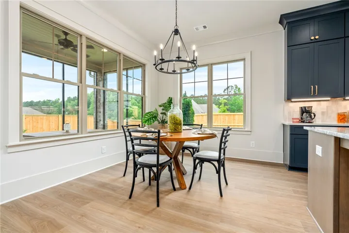 This bright dining area features ample natural light and a charming chandelier, perfect for intimate gatherings.