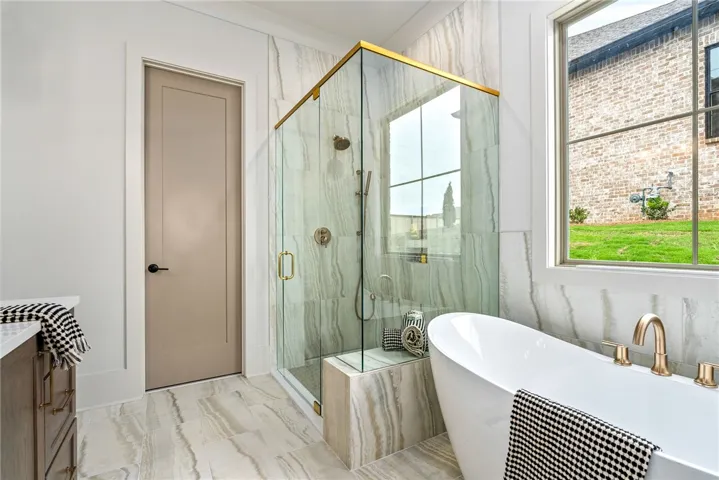 This primary bathroom features a freestanding tub and a spacious glass-enclosed shower.