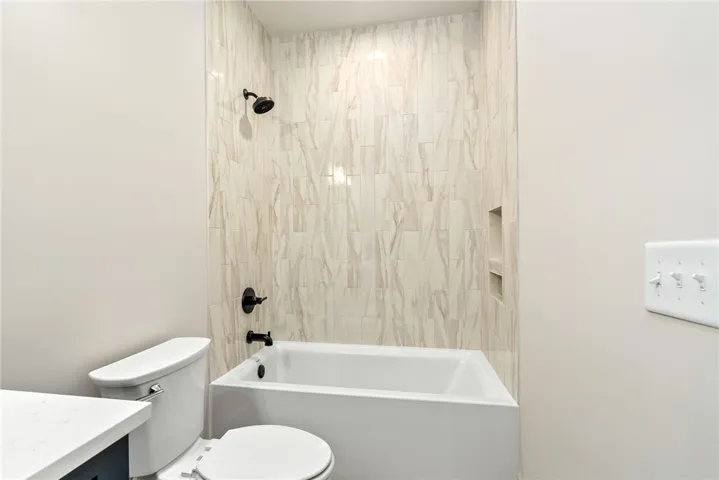 This bathroom features a sleek bathtub and modern tile surround.