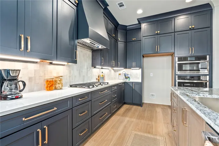 This modern kitchen features rich cabinetry, sleek countertops, and integrated appliances, perfect for culinary pursuits.