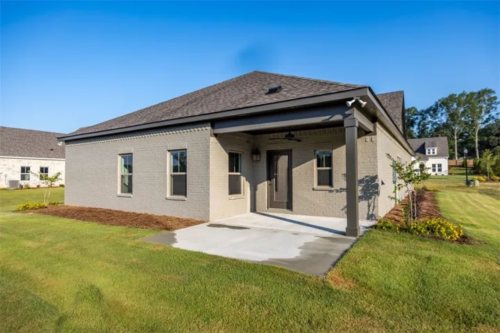 Spacious covered patio overlooking a wide, landscaped backyard perfect for outdoor dining and quiet mornings.