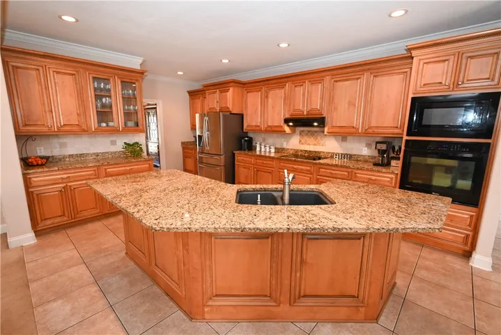 Spacious kitchen with large kitchen and bar seating.