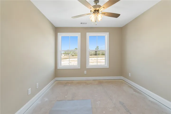 This versatile space features dual windows and a ceiling fan, offering comfort and natural light.
