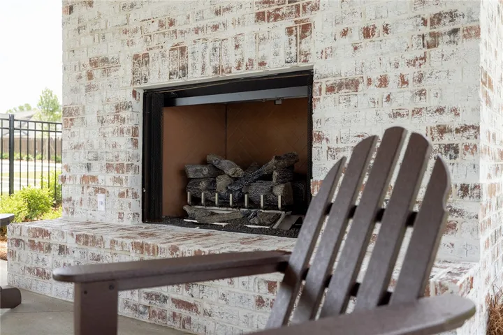 An inviting outdoor fireplace crafted from white-washed brick offers a cozy gathering space.