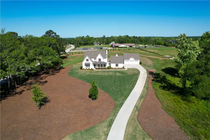 This impressive home boasts a long, winding driveway leading to a spacious garage.