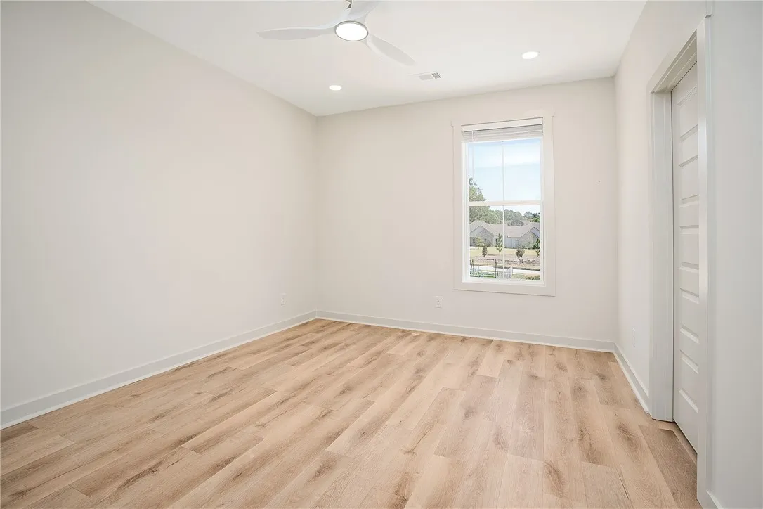 Gleaming hardwood floors and a single window define this versatile secondary bedroom space.