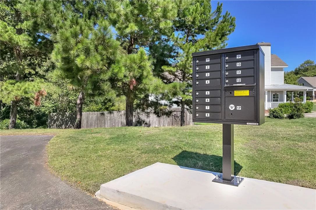 Lush mature trees and a grassy lawn surround the community common areas.