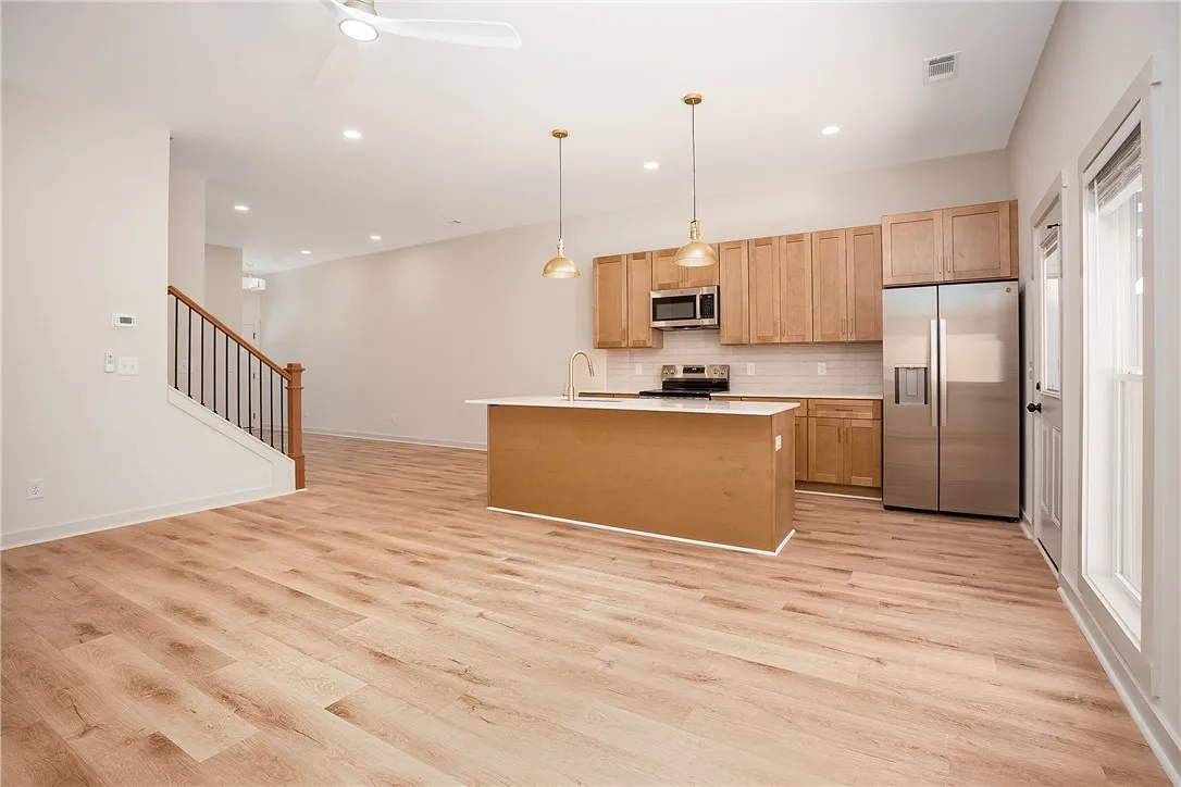 Warm wood floors flow through a contemporary open-concept kitchen and living area.