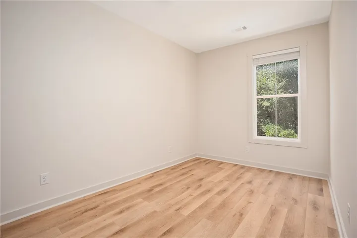 Smooth wood floors and a classic sash window define this versatile, neutral-toned room.
