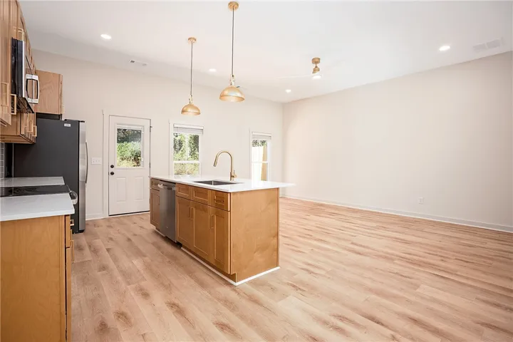 Gleaming wood floors anchor an airy, light-filled layout with a central functional kitchen island.