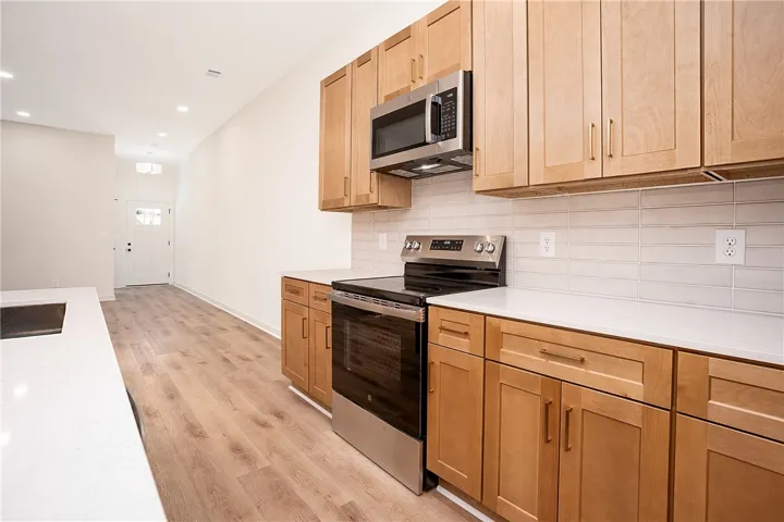 Gleaming stone countertops and wood cabinetry define this modern open kitchen layout.