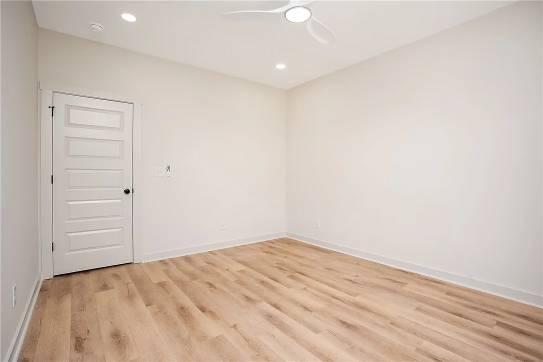 Warm wood flooring and clean white walls create a highly versatile secondary bedroom.