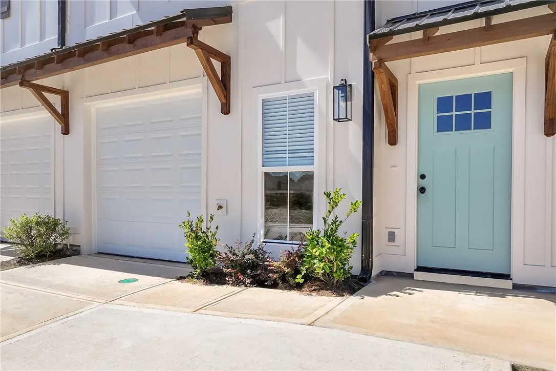 Modern vertical siding and warm wood accents frame this inviting townhome entry.