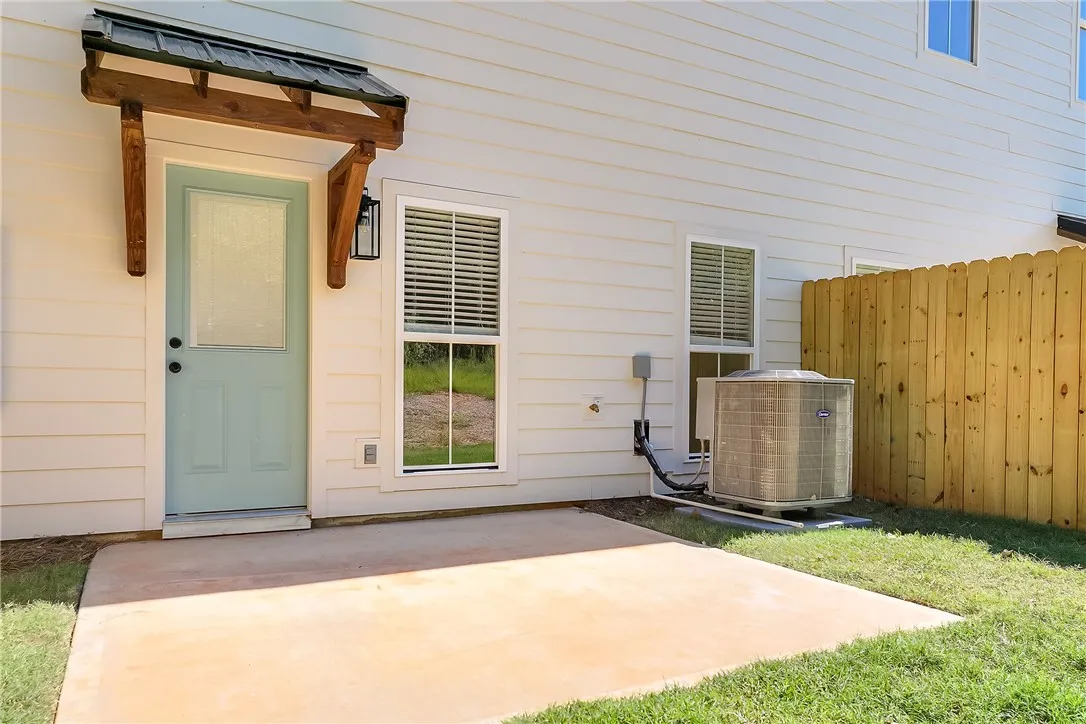 An inviting concrete patio steps out to a fenced backyard space.