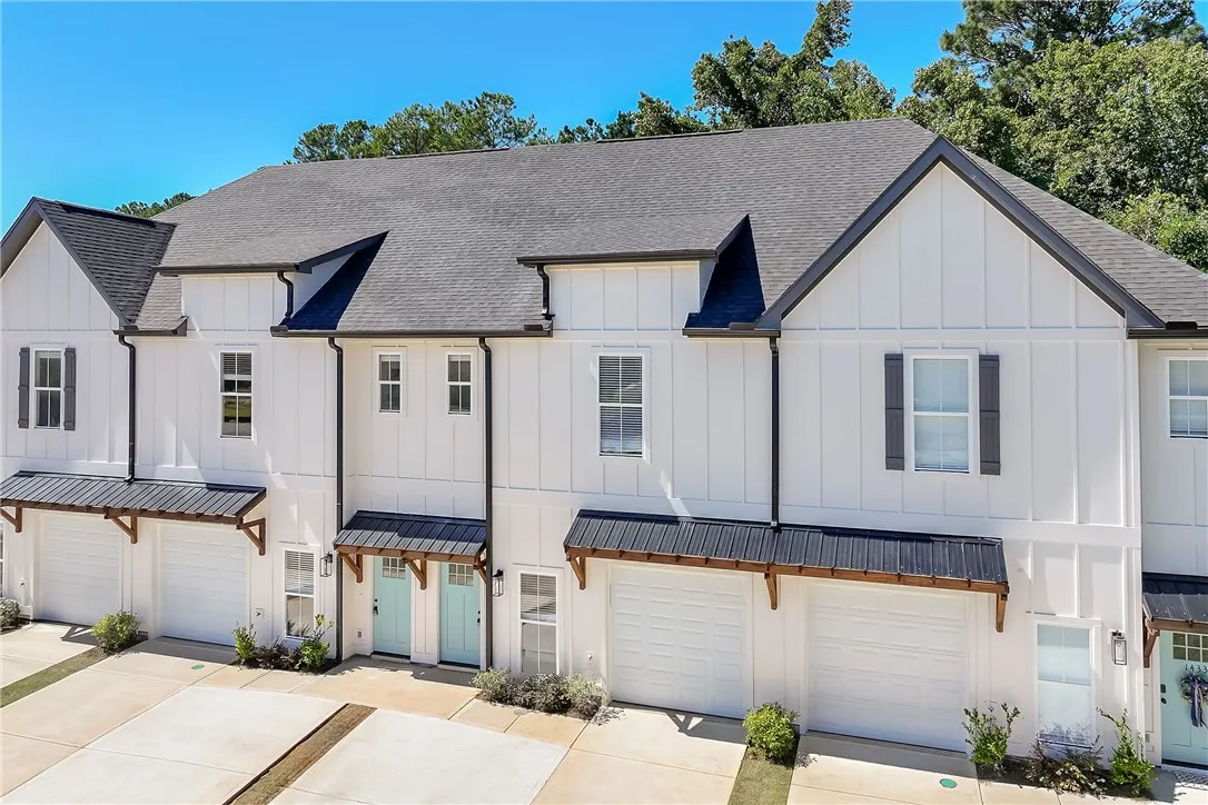 Crisp board and batten siding pairs with dark gables on this modern multi-unit exterior.