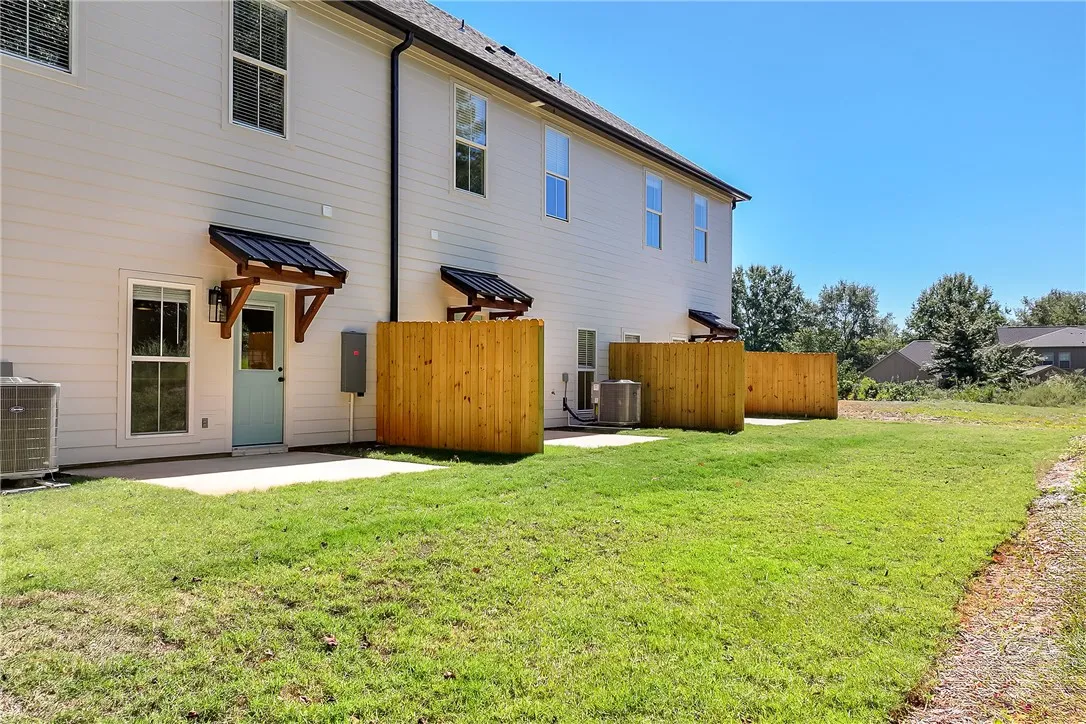 A manicured lawn extends from concrete patios complete with wooden privacy partitions.