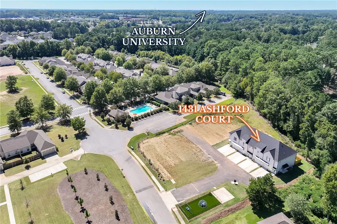 An aerial perspective showcases the neighborhood layout nestled near mature woodlands.
