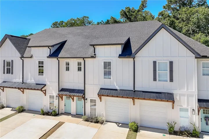 Crisp board and batten siding pairs with dark gables on this modern multi-unit exterior.