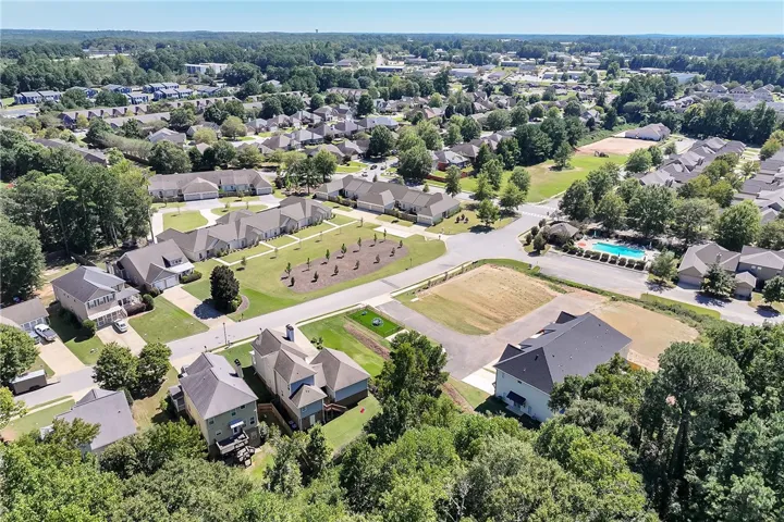 An aerial perspective captures a peaceful residential community surrounded by mature trees.