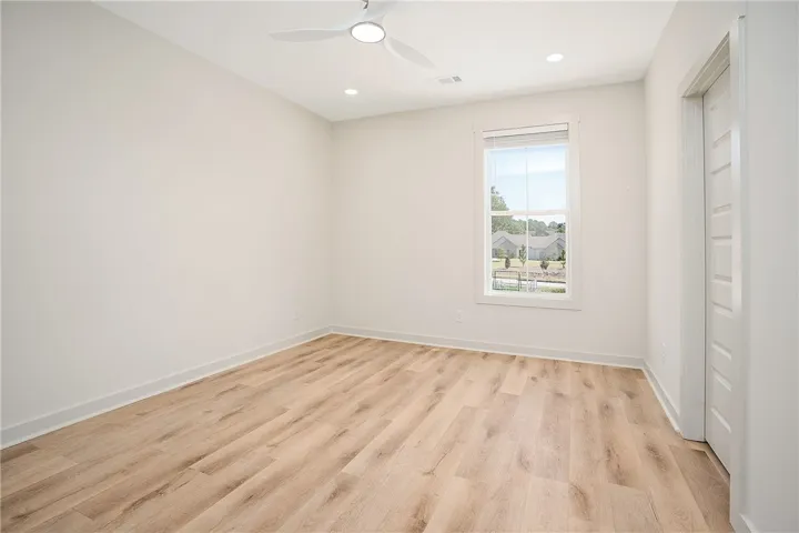 Gleaming hardwood floors and a tall window bring warmth to this versatile secondary room.