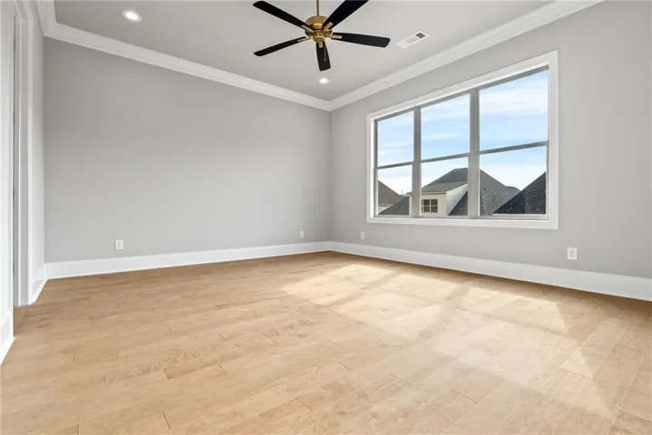 Bedroom 2 with wood flooring, a built-in bookshelf, great natural light, a fan, and recessed lighting.