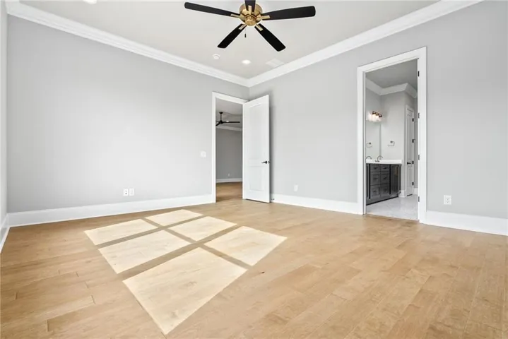 The spacious primary bedroom features wood flooring and a triple window.