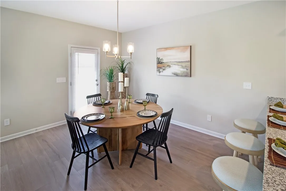 This bright dining area features an open floorplan with durable flooring.