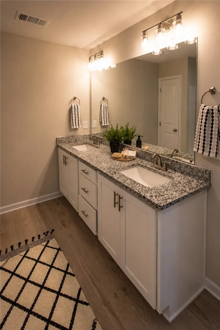 Dual vanity with elegant granite counters provides ample space and sophisticated utility.