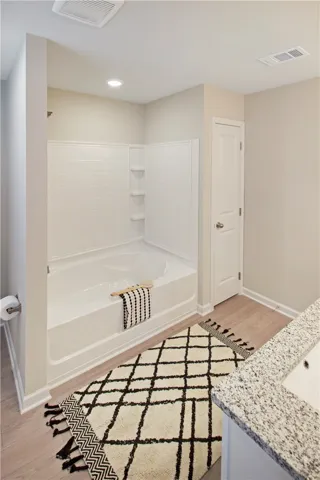 This bathroom features a deep soaking tub, perfect for unwinding after a long day.