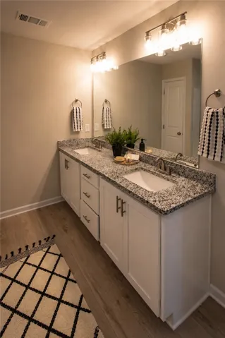 Dual vanity with elegant granite counters provides ample space and sophisticated utility.
