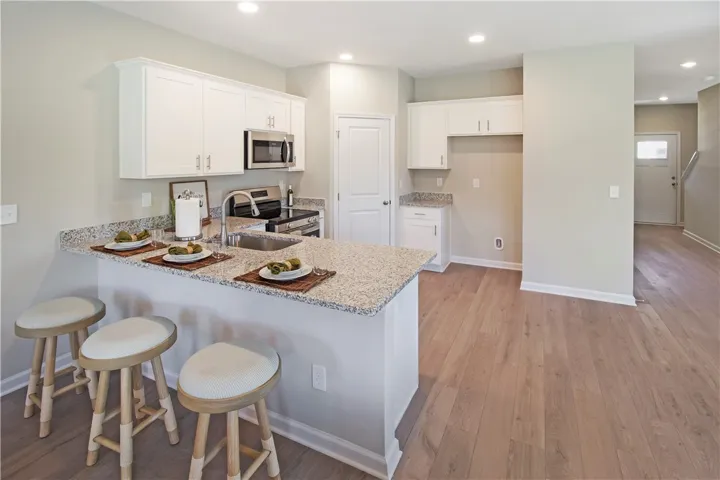 This bright kitchen features ample counter space and hardwood flooring throughout the open layout.