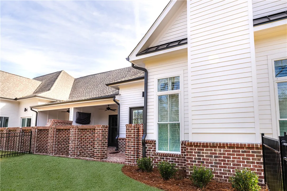 This residence showcases a seamless blend of brick and siding, complemented by an inviting covered porch.