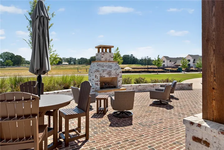 This inviting patio area features a charming fireplace, perfect for enjoying outdoor gatherings.