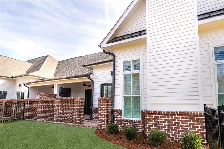 This residence showcases a seamless blend of brick and siding, complemented by an inviting covered porch.