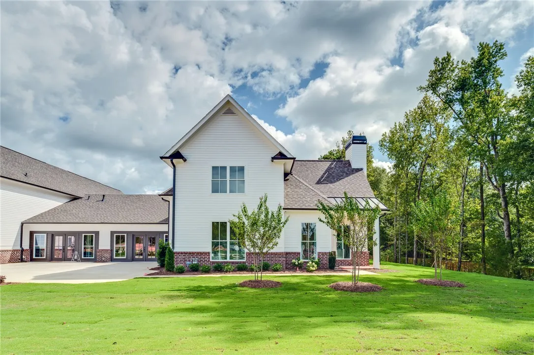 This classic white home with brick accents features a prominent chimney and a well-kept yard.