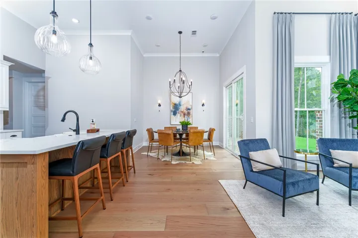 This bright, open concept living and dining area features rich wood flooring and expansive natural light.