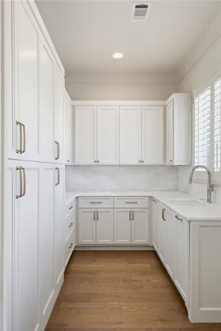 Custom cabinetry and polished stone countertops elevate this well-appointed utility space.