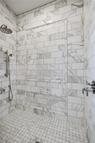 Marble-clad shower with integrated shelving offers a spa-like bathing experience.