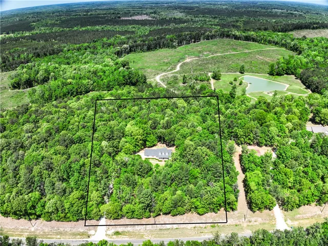 This serene aerial view captures a secluded home nestled within expansive greenery, offering ultimate privacy and natural beauty.