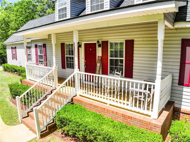 This charming residence features a welcoming porch, perfect for enjoying peaceful mornings or relaxing evenings.