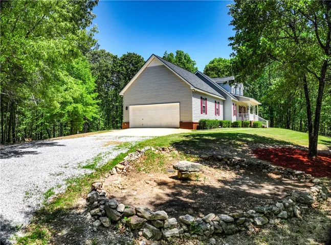 This charming home features a lovely exterior, surrounded by lush trees and a well-maintained yard.