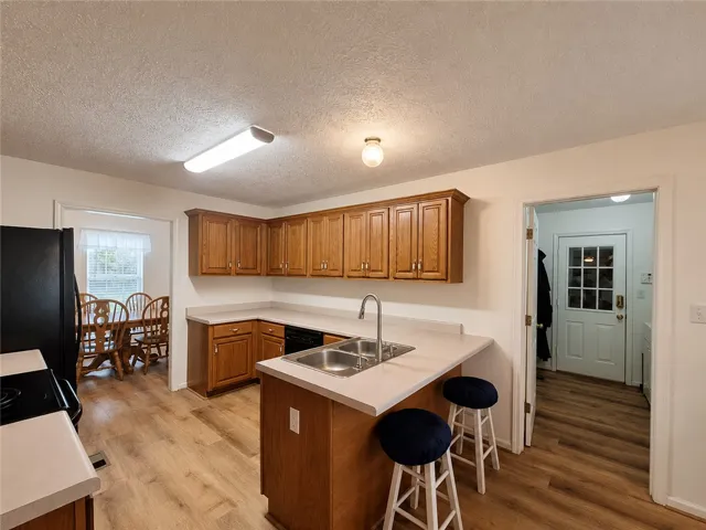 A functional kitchen with wood cabinetry and an integrated sink provides an inviting culinary space.
